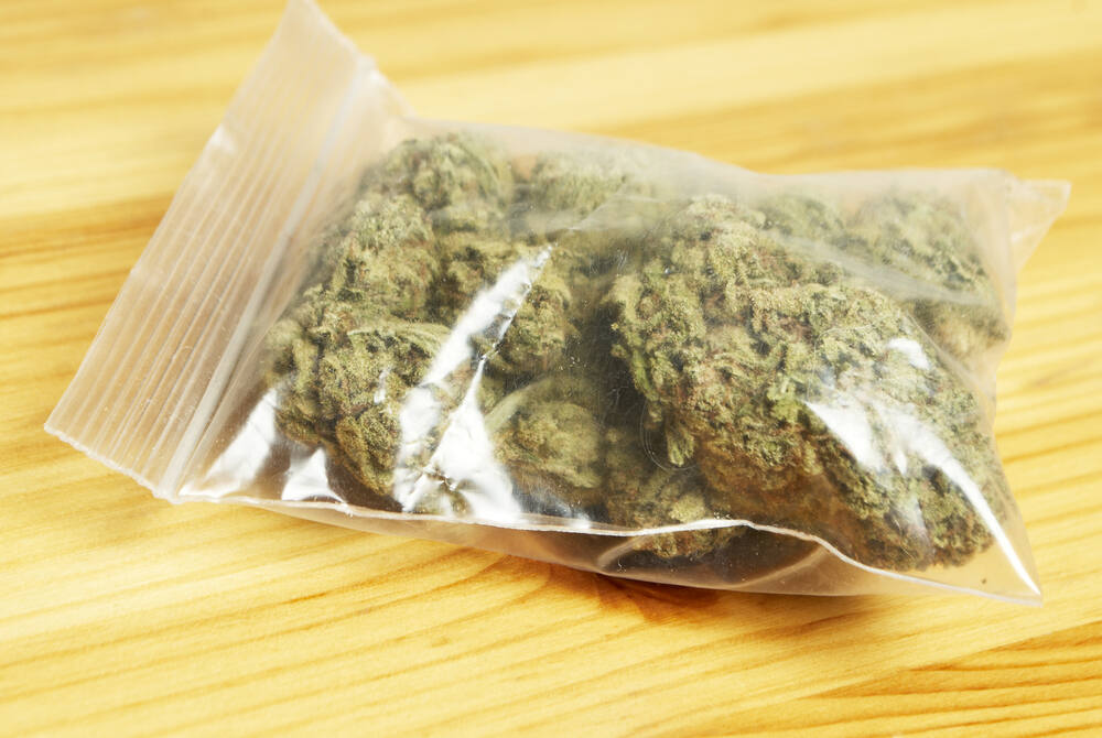 an eighth of weed in a see through baggie on a wooden table