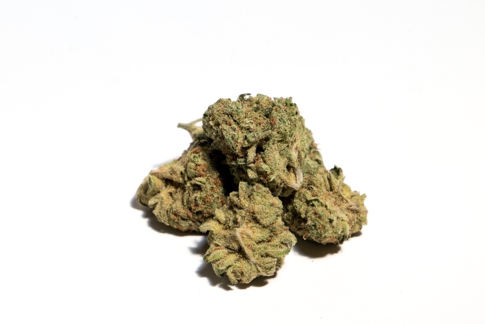 an eighth of cannabis bud the size of a golf ball on a white background